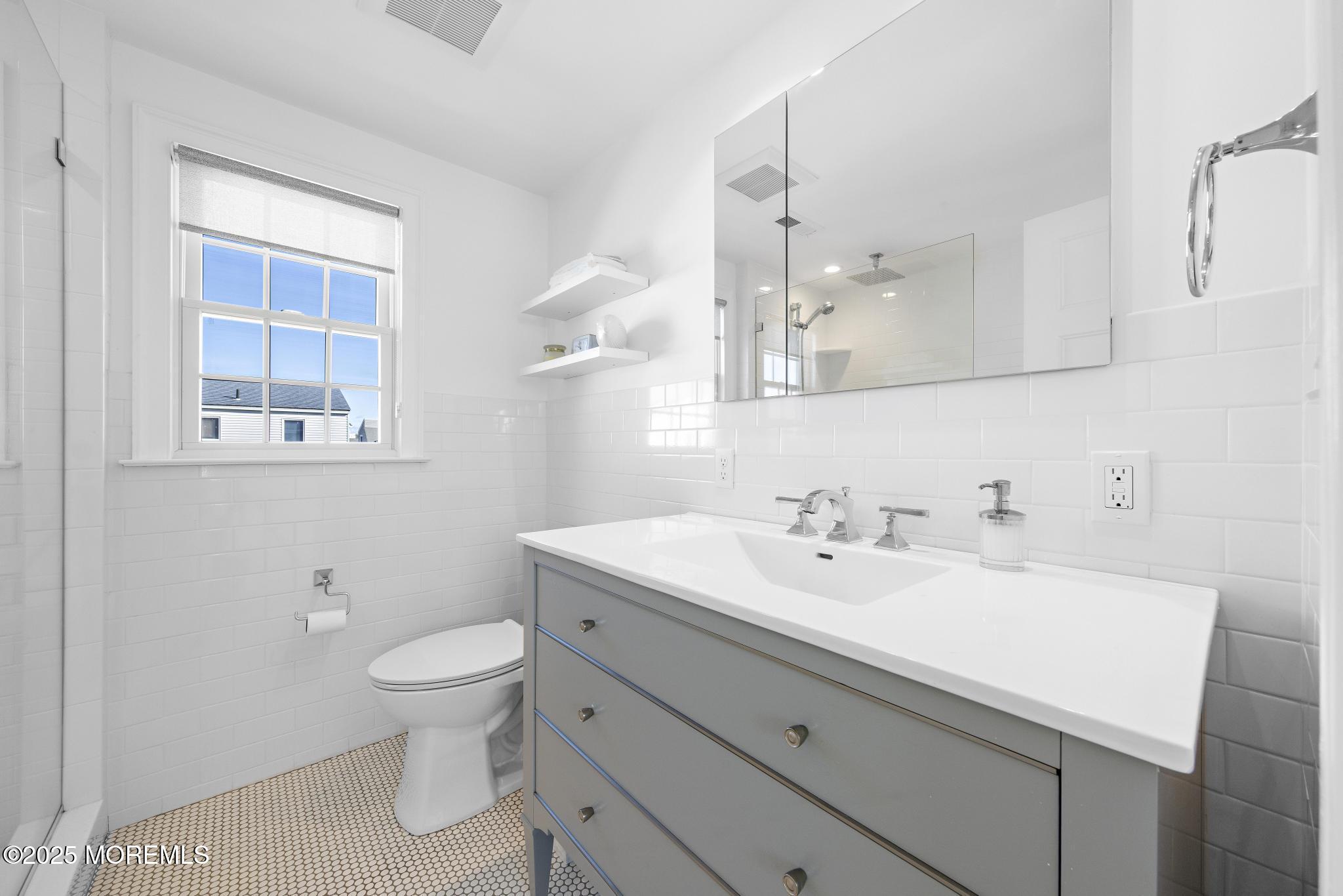 9 Inlet Road Beach Haven, NJ 08008 - Photo 25 of 51 a bathroom with a toilet sink and mirror