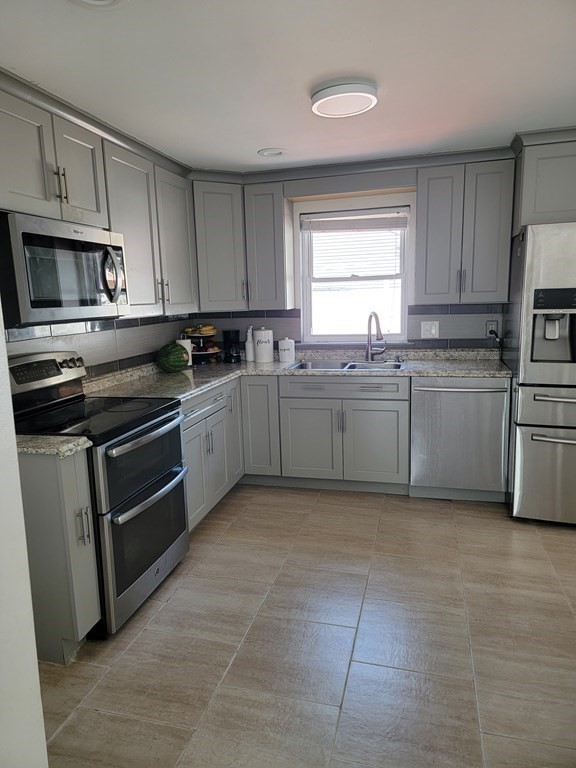 192 Starling Road Springfield, MA 01119 - Photo 14 of 26 a kitchen with stainless steel appliances granite countertop a stove a sink and a refrigerator