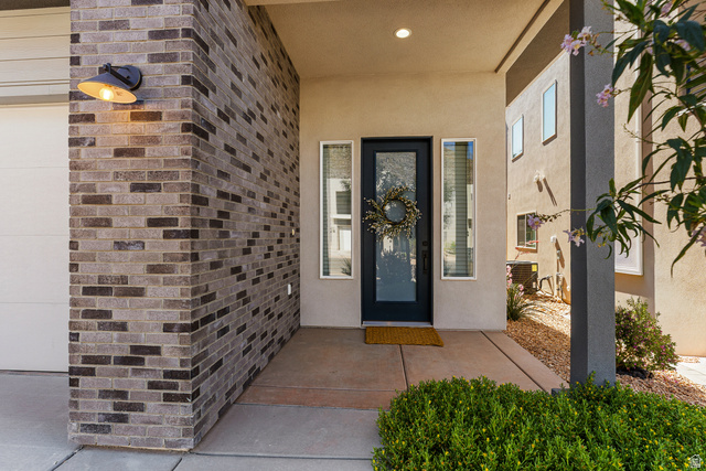 839 Walker Way St. George, UT 84770 - Photo 16 of 32 Contemporary entryway featuring a dark-framed glass door, complementary sidelight, recessed ceiling lighting, and a textured brick facade