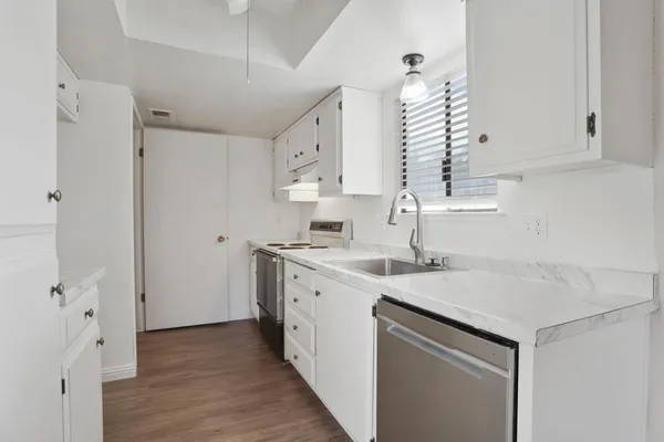 a kitchen with a sink cabinets and wooden floor