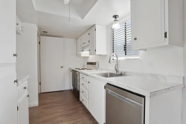 a kitchen with a sink cabinets and wooden floor