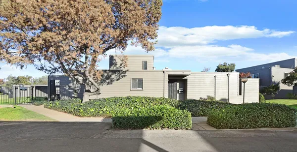 a front view of a house with a yard and potted plants