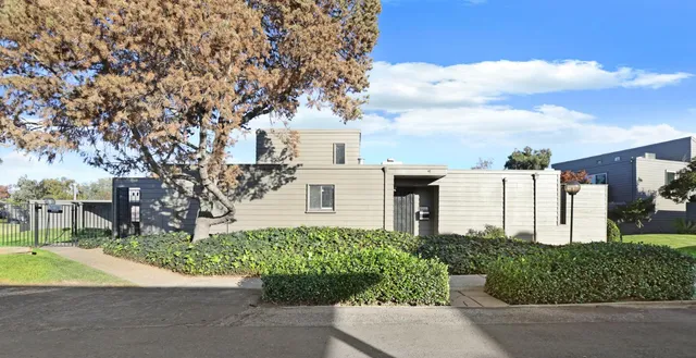 a front view of a house with a yard and potted plants
