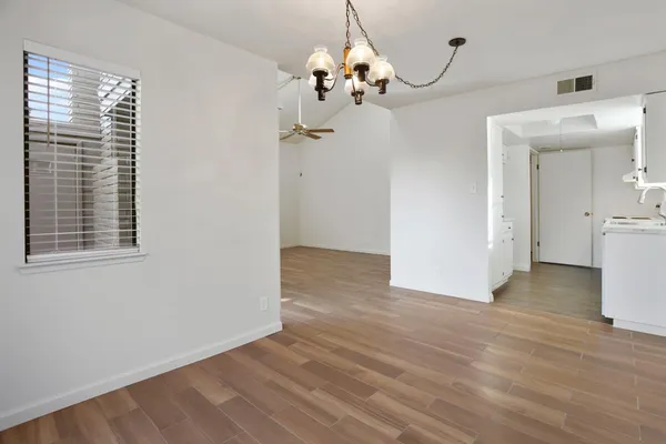 a view of a room with wooden floor and chandelier