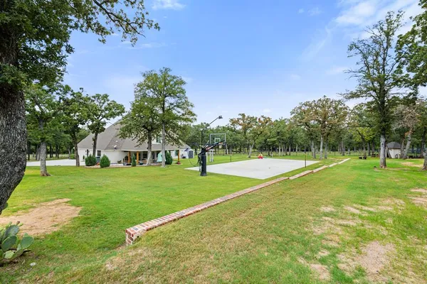 a view of a house with a big yard and palm trees