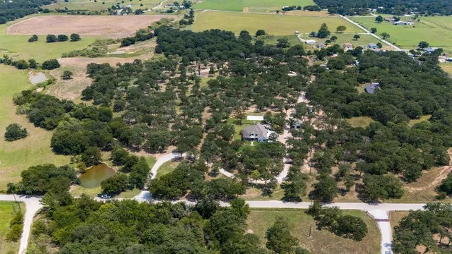 an aerial view of residential houses with outdoor space and trees all around