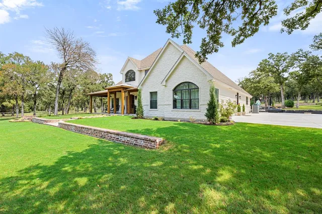 a front view of a house with a garden and yard