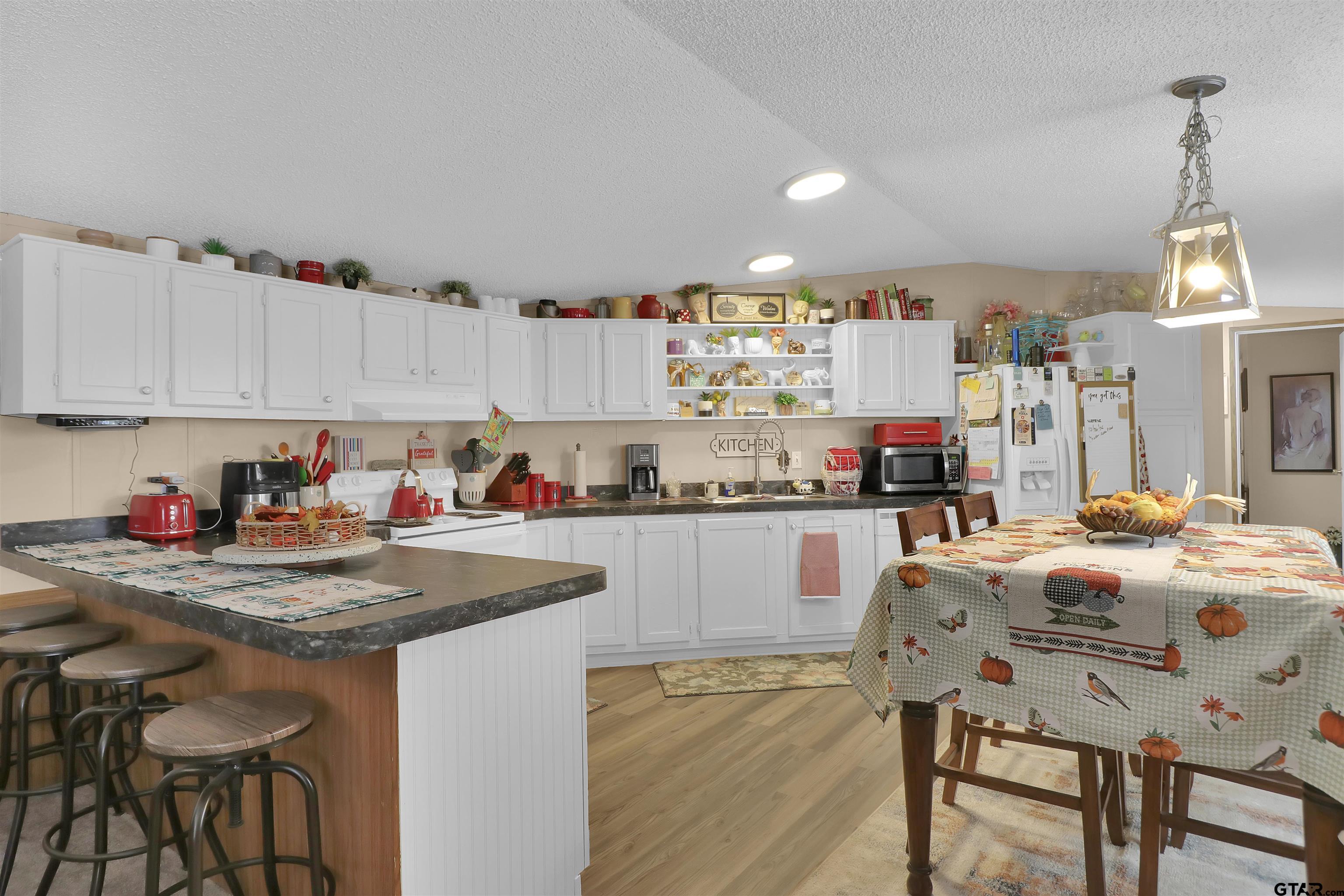 602 North Commerce Street Overton, TX 75684 - Photo 5 of 17 a kitchen with granite countertop a table chairs stove and cabinets