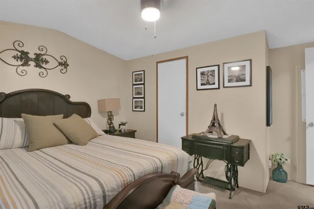 a bedroom with bed and a painting on the wall