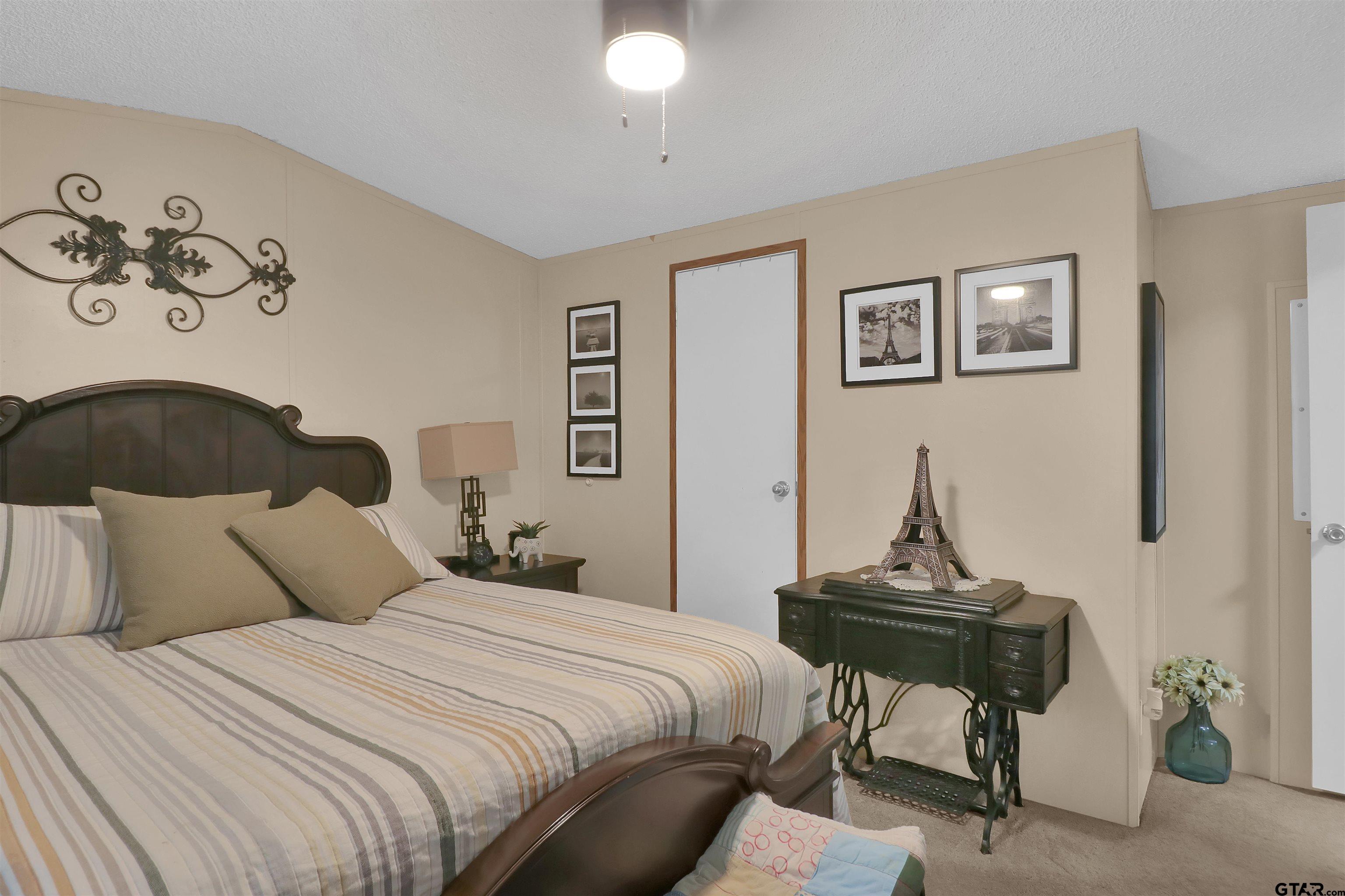 602 North Commerce Street Overton, TX 75684 - Photo 7 of 17 a bedroom with bed and a painting on the wall