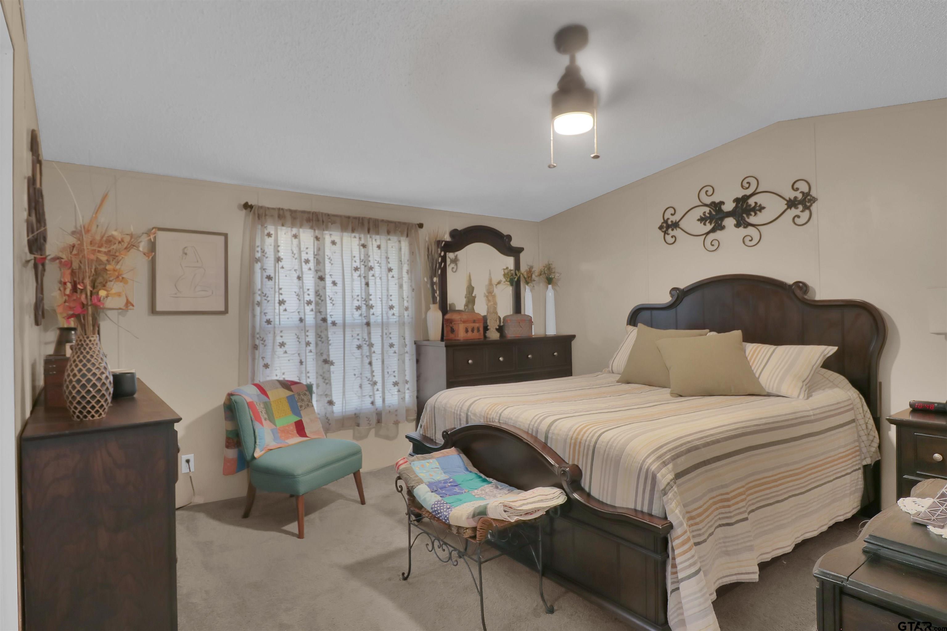 602 North Commerce Street Overton, TX 75684 - Photo 8 of 17 a bedroom with a bed and a chandelier