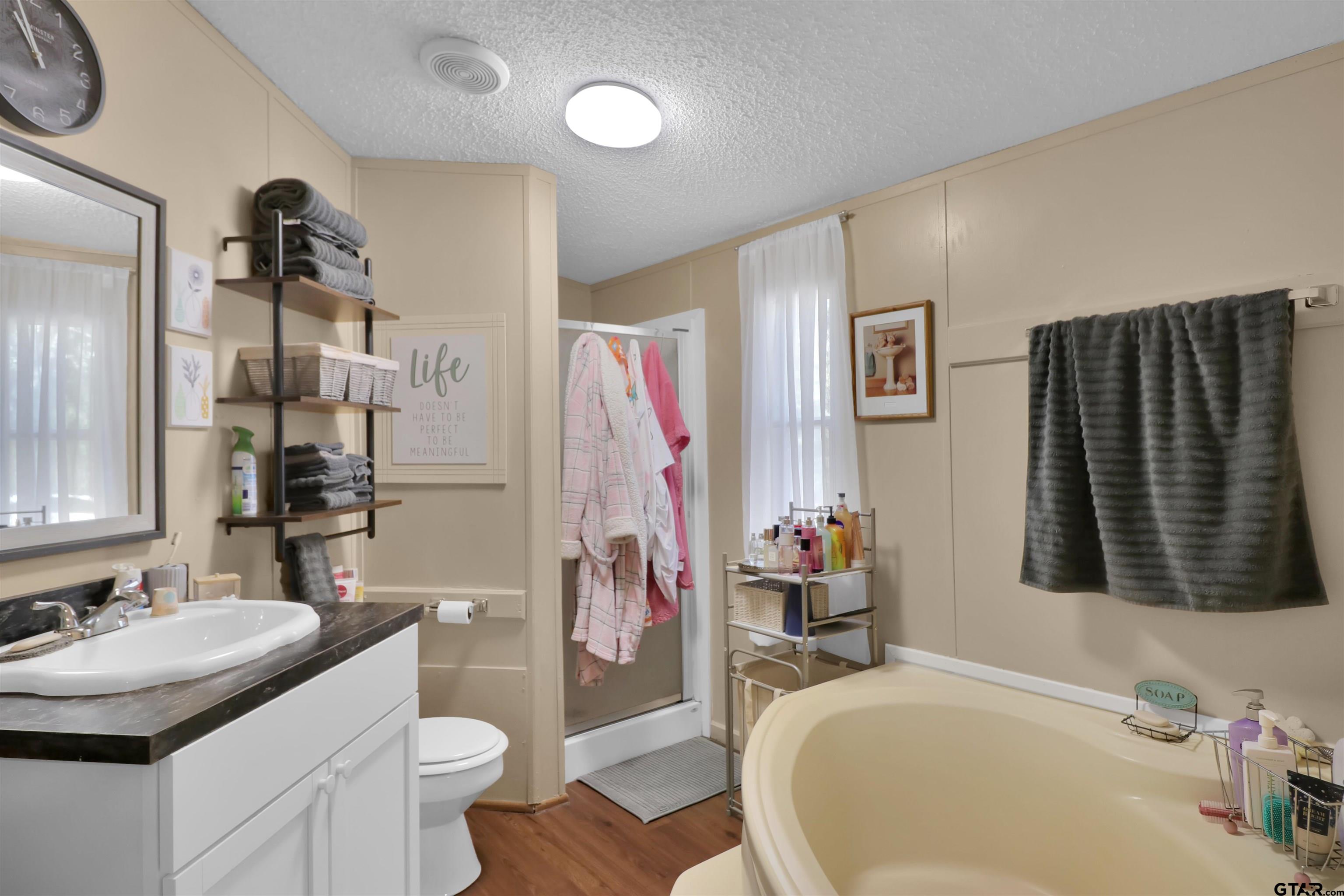 602 North Commerce Street Overton, TX 75684 - Photo 9 of 17 a bathroom with a granite countertop sink and a mirror