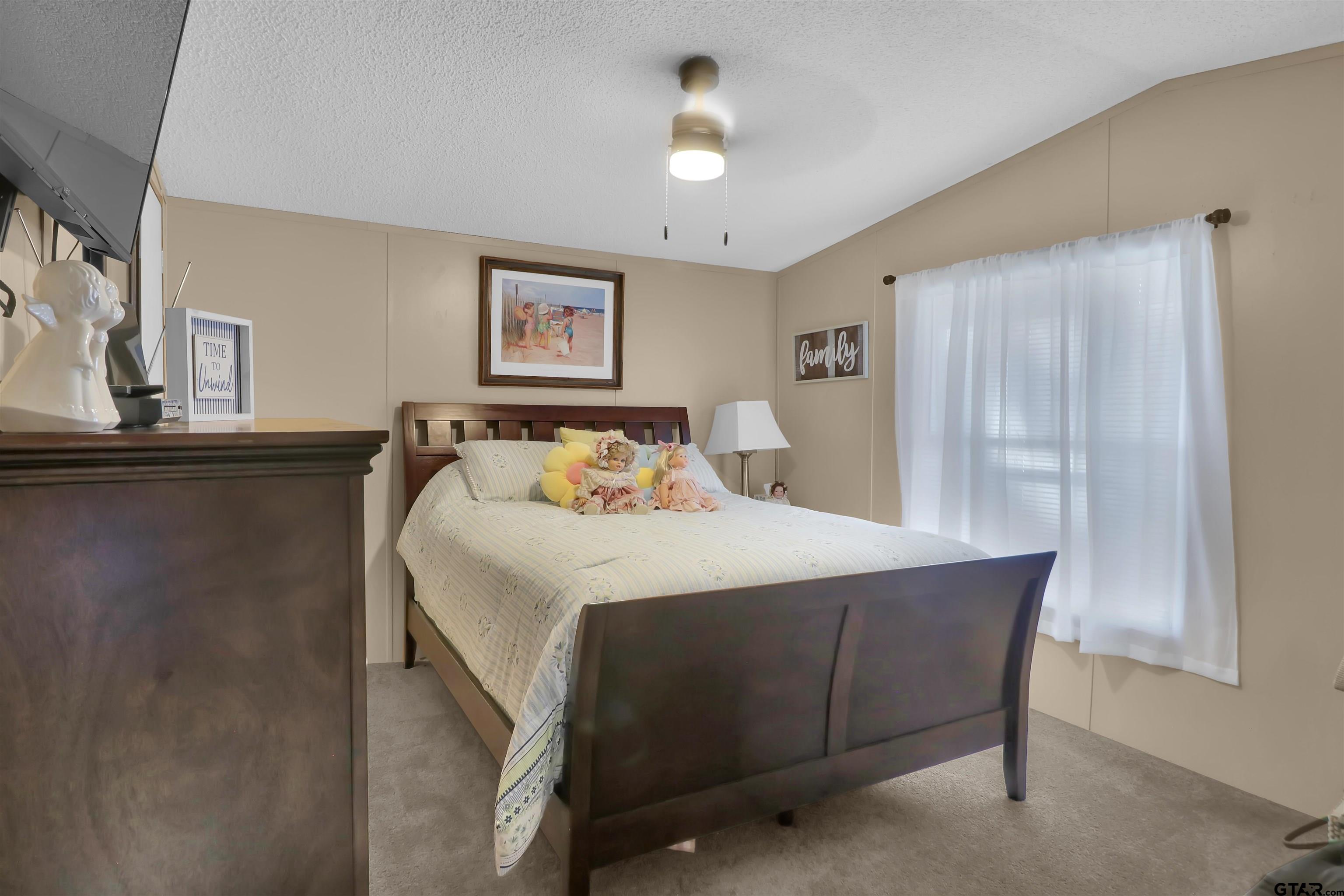 602 North Commerce Street Overton, TX 75684 - Photo 10 of 17 a bedroom with a bed and a chandelier