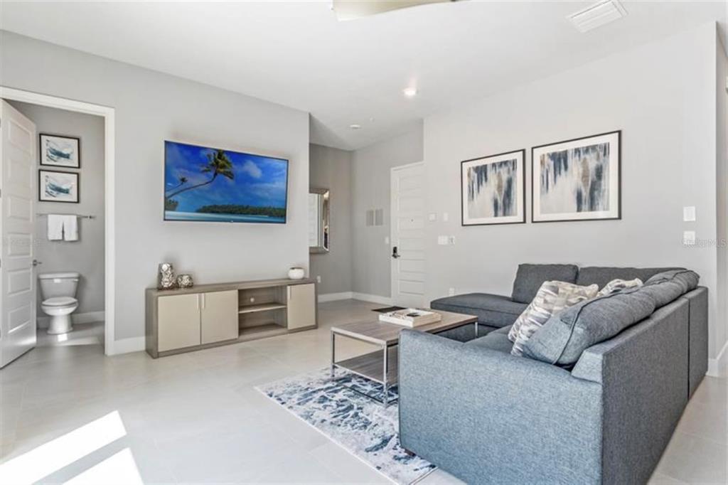7760 Sandy Ridge Drive, Unit 108 Reunion, FL 34747 - Photo 3 of 16 a living room with furniture and a flat screen tv