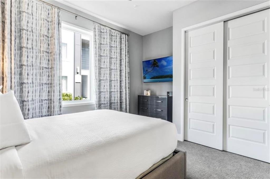 7760 Sandy Ridge Drive, Unit 108 Reunion, FL 34747 - Photo 4 of 16 a spacious bedroom with a bed and a dresser