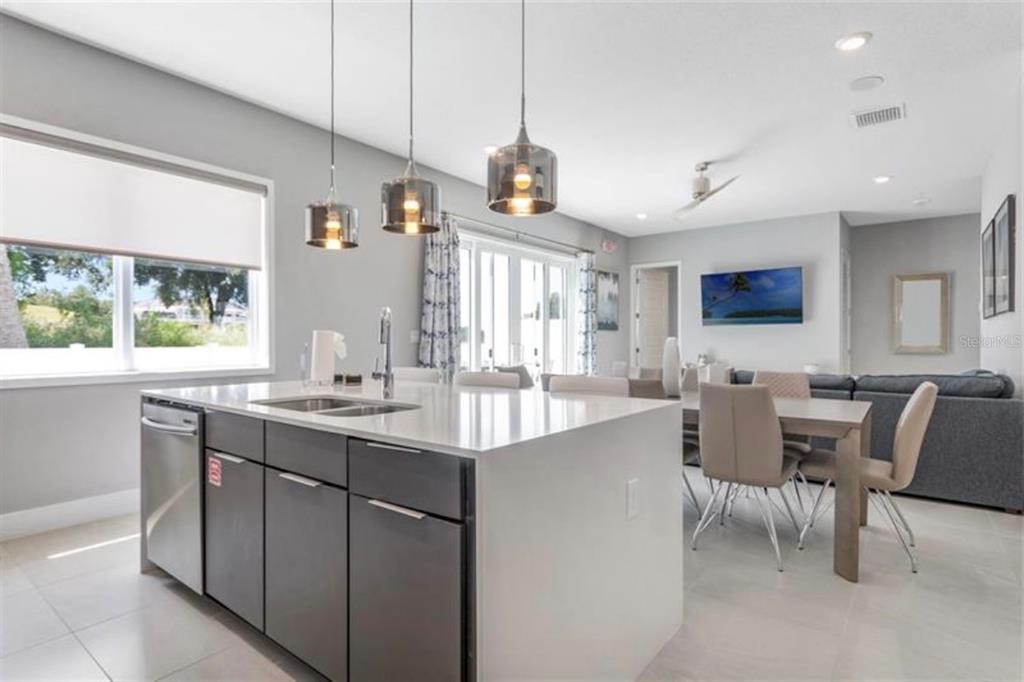 7760 Sandy Ridge Drive, Unit 108 Reunion, FL 34747 - Photo 8 of 16 a kitchen with center island table and chairs