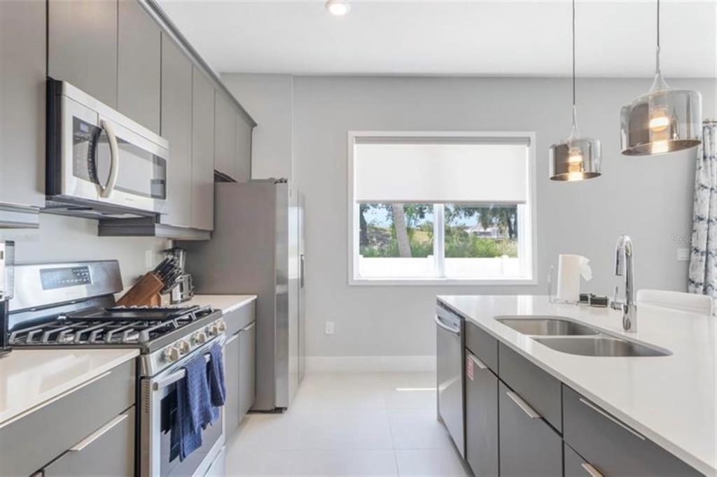 7760 Sandy Ridge Drive, Unit 108 Reunion, FL 34747 - Photo 9 of 16 a kitchen with stainless steel appliances granite countertop a sink stove and refrigerator