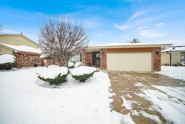 a front view of a house with a yard covered in snow