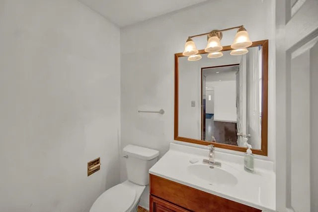 a bathroom with a sink vanity mirror and toilet