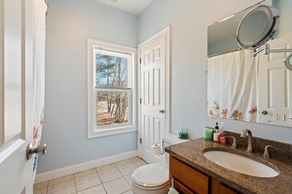 496 Main Street, Unit 2 Hanson, MA 02341 - Photo 11 of 20 a bathroom with a granite countertop sink a toilet and a mirror