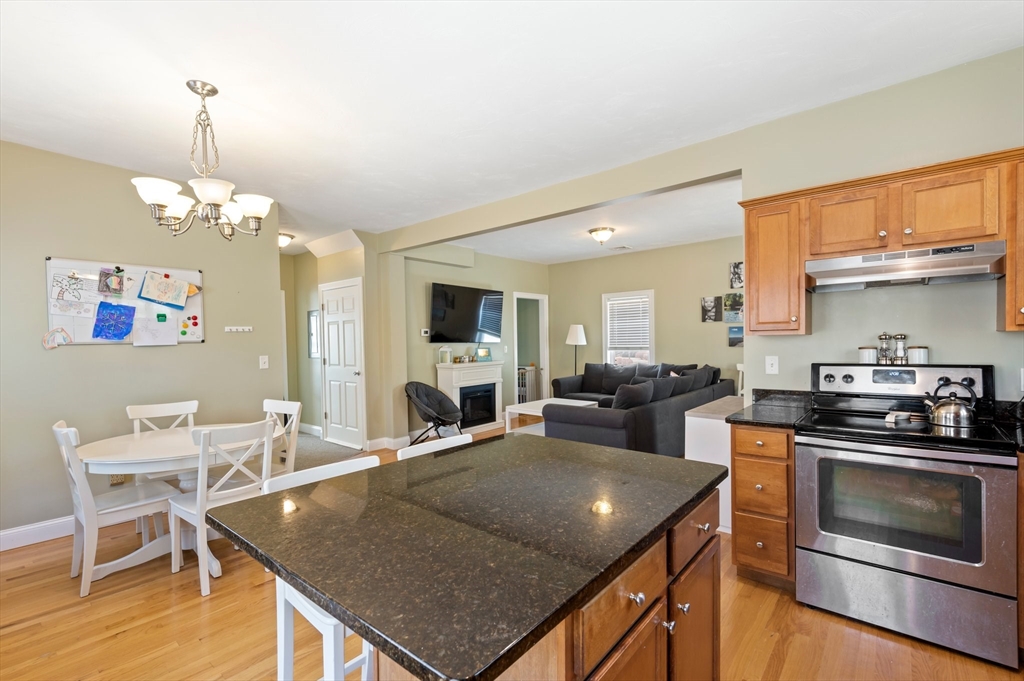 496 Main Street, Unit 2 Hanson, MA 02341 - Photo 7 of 20 a kitchen with stove and chairs