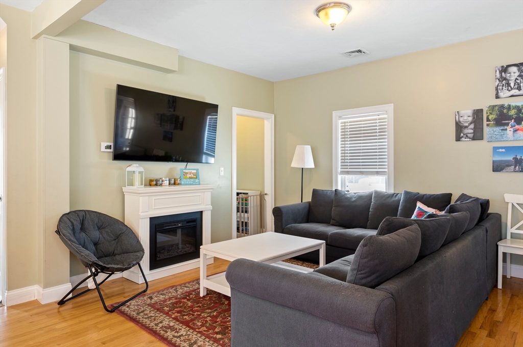 496 Main Street, Unit 2 Hanson, MA 02341 - Photo 9 of 20 a living room with furniture a fireplace and a flat screen tv
