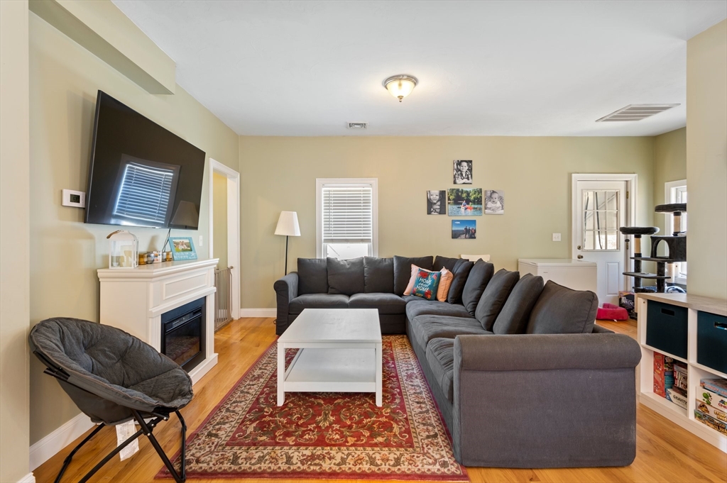 496 Main Street, Unit 2 Hanson, MA 02341 - Photo 10 of 20 a living room with furniture a flat screen tv and a fireplace
