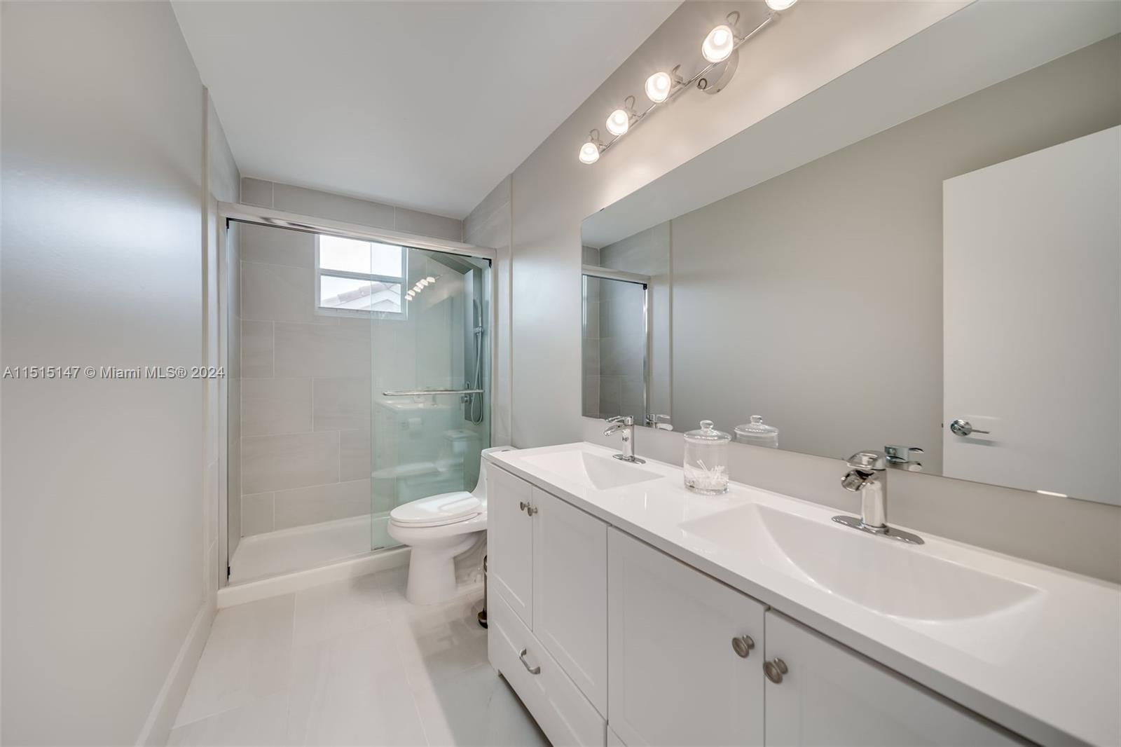 958 Briar Ridge Road Weston, FL 33327 - Photo 42 of 55 a bathroom with a double vanity sink toilet and a mirror