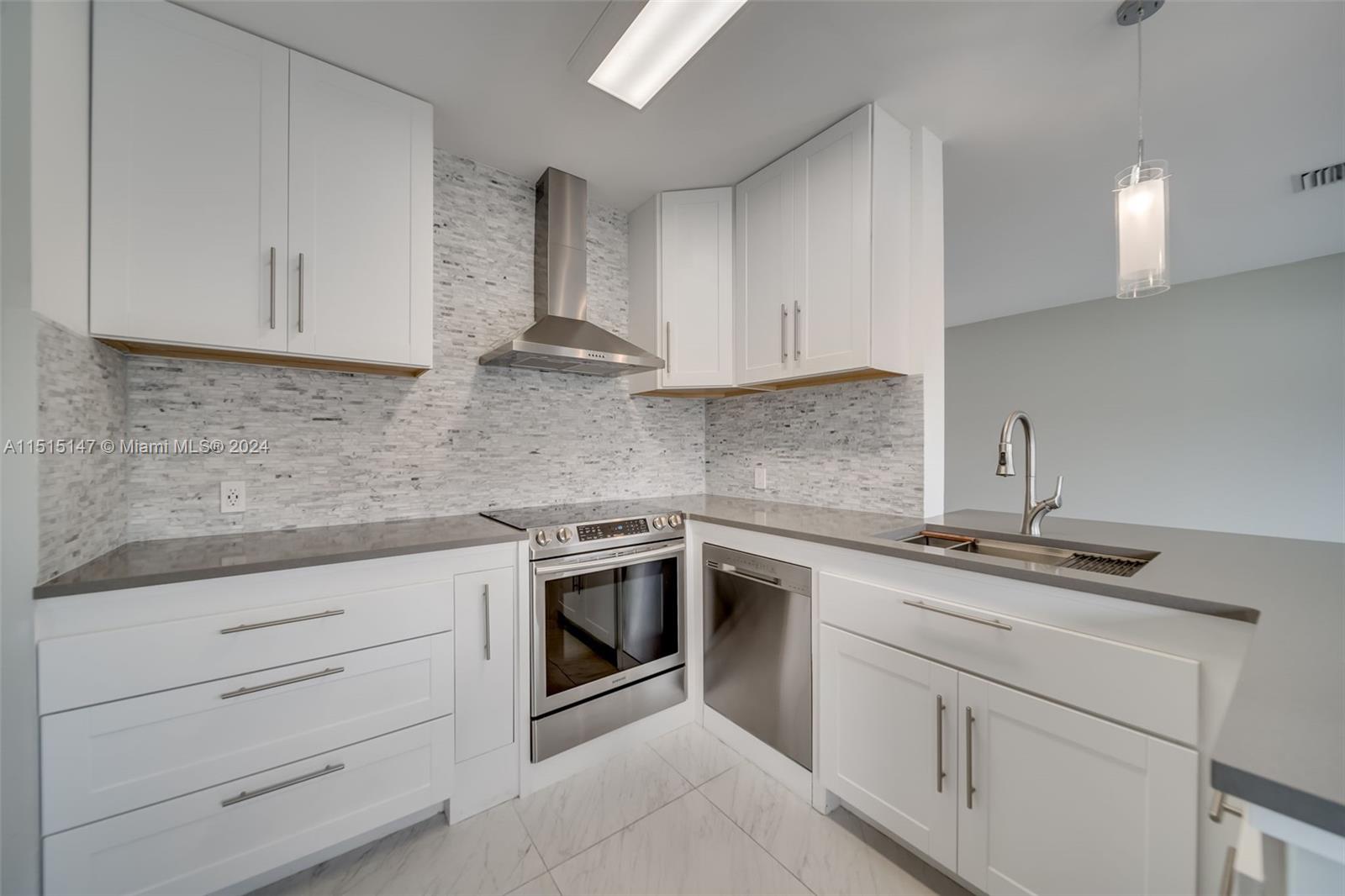 958 Briar Ridge Road Weston, FL 33327 - Photo 5 of 55 a kitchen with white cabinets stainless steel appliances and sink