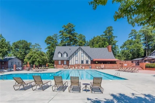 an aerial view of a house with swimming pool and a yard