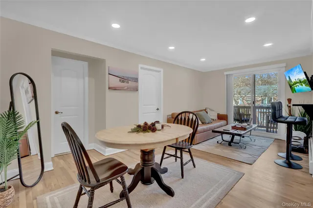 a view of a a dining room with furniture window and wooden floor