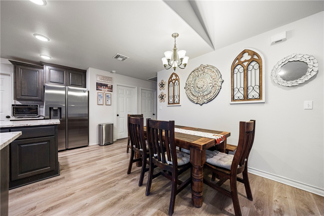 9227 Baker Road Sinton, TX 78387 - Photo 13 of 23 a view of dining room and kitchen with furniture wooden floor and a clock