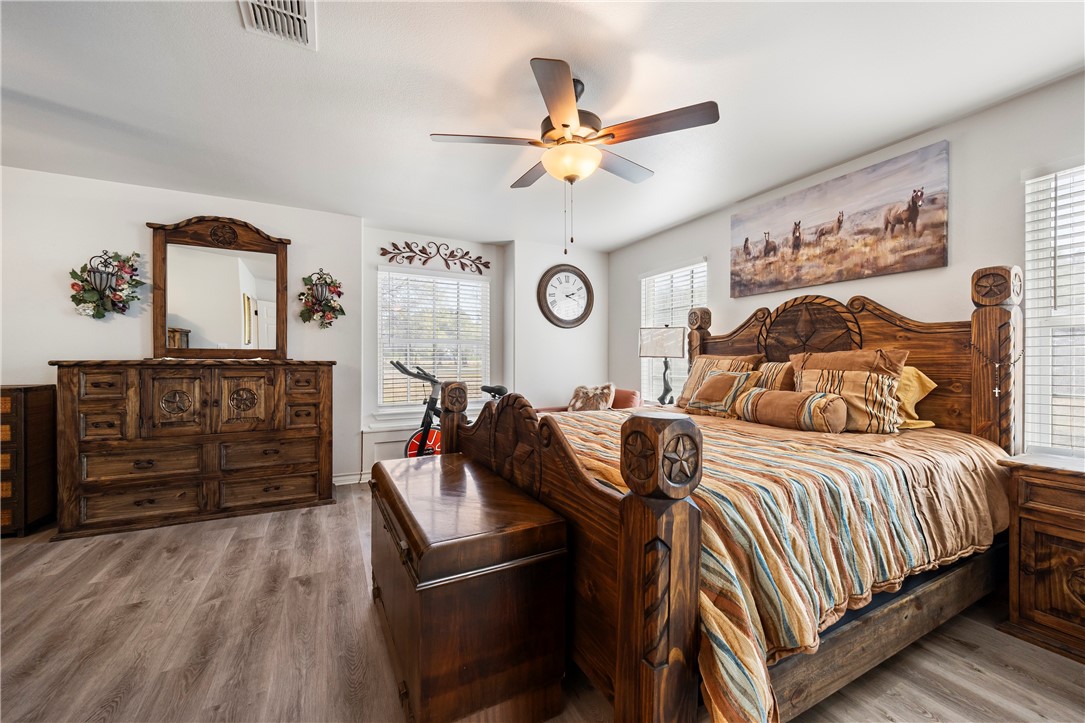 9227 Baker Road Sinton, TX 78387 - Photo 19 of 28 a bedroom with a bed and wooden floor