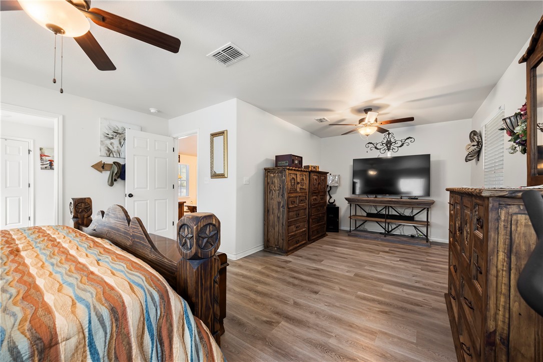 9227 Baker Road Sinton, TX 78387 - Photo 20 of 28 a bedroom with furniture a flat screen tv and a ceiling fan