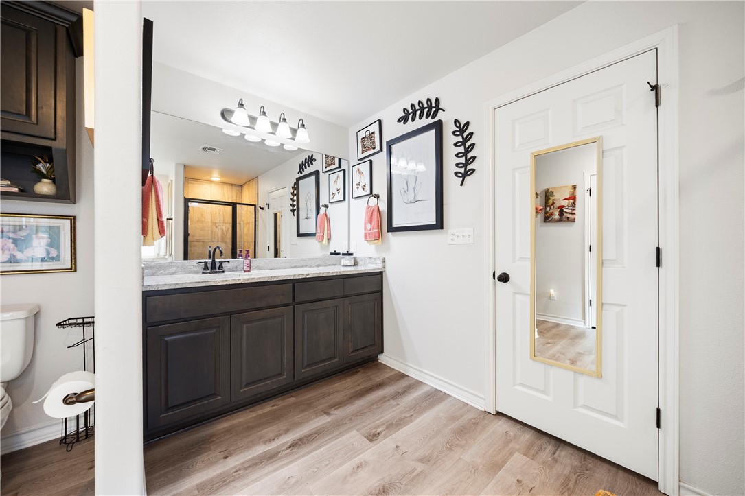 9227 Baker Road Sinton, TX 78387 - Photo 22 of 28 a spacious bathroom with a double vanity sink toilet and shower