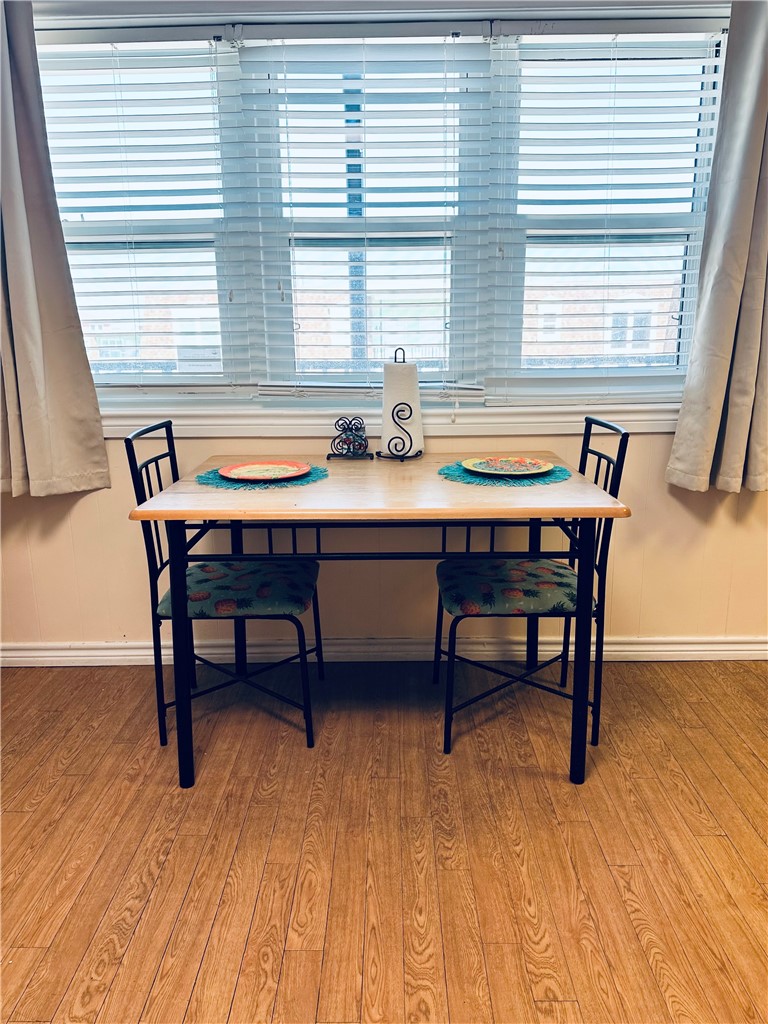 700 Island Retreat Road, Unit 14 Port Aransas, TX 78373 - Photo 15 of 23 a dining room with wooden floor and windows