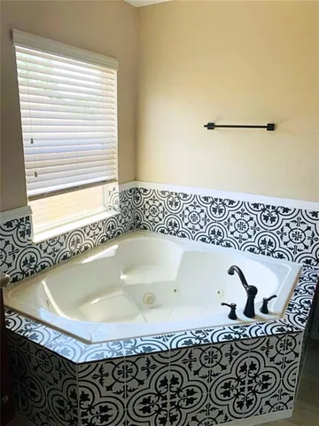 a bath tub sitting in a bathroom next to a window