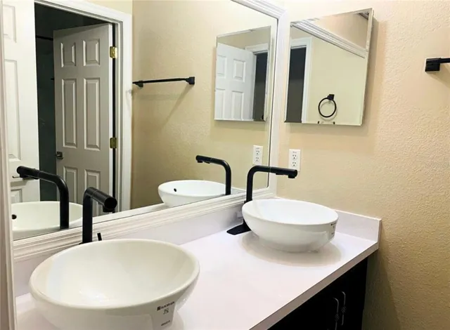 a bathroom with a sink a toilet and mirror
