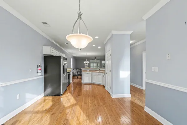 a kitchen with stainless steel appliances granite countertop a stove a sink dishwasher a refrigerator and a microwave oven with wooden floor