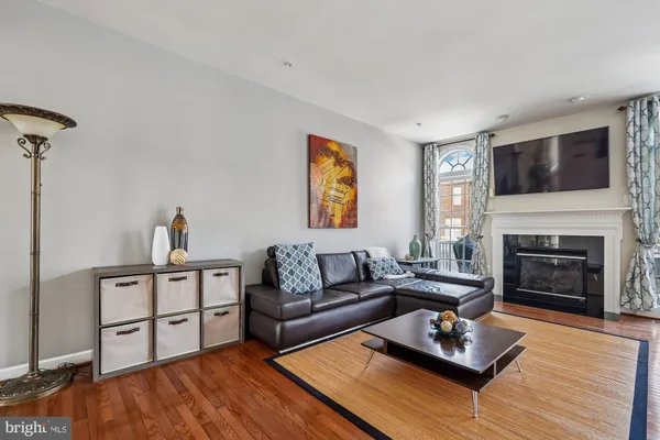 a living room with furniture fireplace and wooden floor