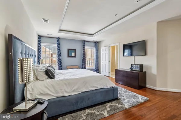 a bedroom with a bed a table and painting on the wall