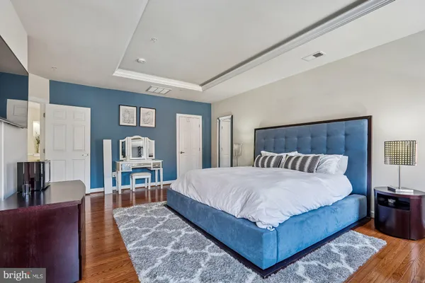 a spacious bedroom with a bed and a flat screen tv