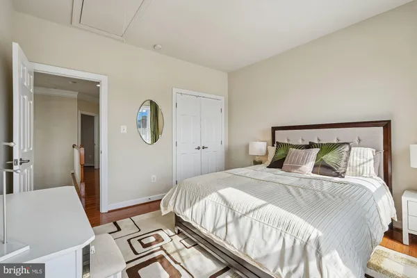 a bedroom with a bed wooden floor and window