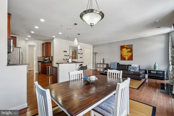 a view of a dining room and livingroom with furniture wooden floor a chandelier