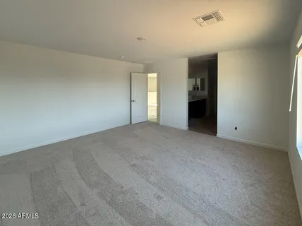 an empty room with an entryway and fan