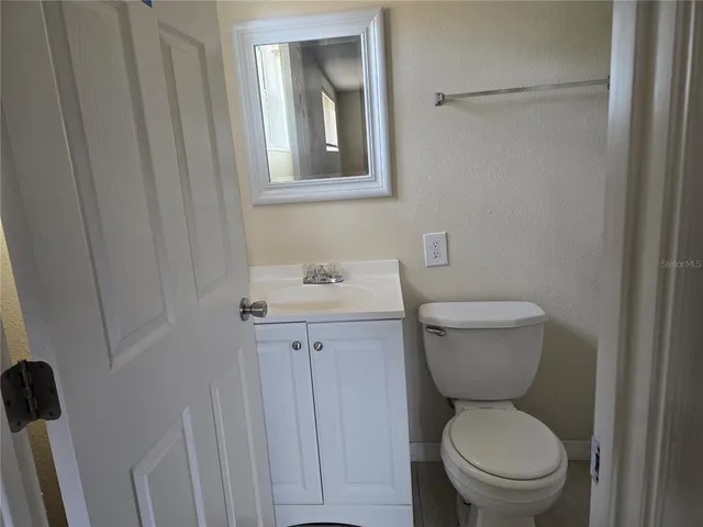 a bathroom with a toilet a sink and mirror