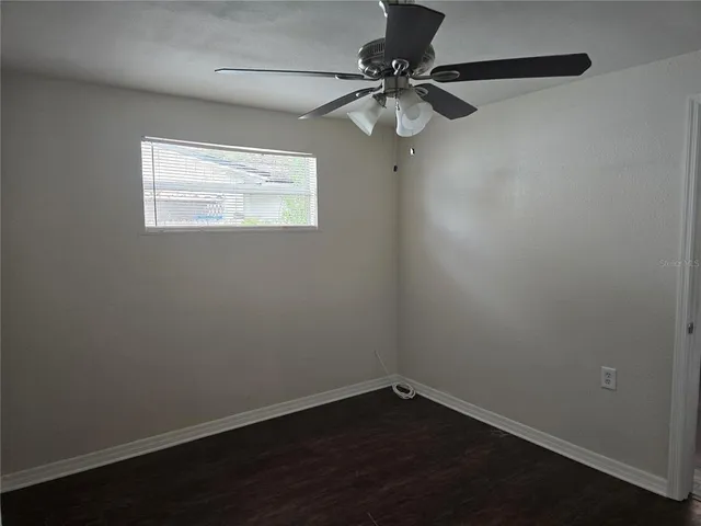 a view of a small space with wooden floor and fan