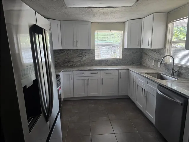 a kitchen with stainless steel appliances granite countertop a refrigerator sink and cabinets