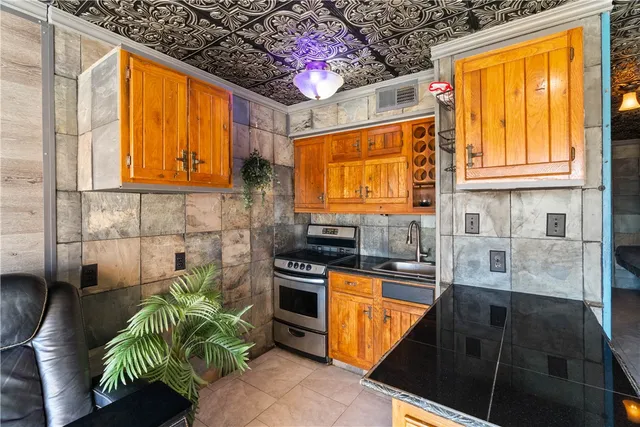 a kitchen with stainless steel appliances granite countertop a stove a sink and a microwave
