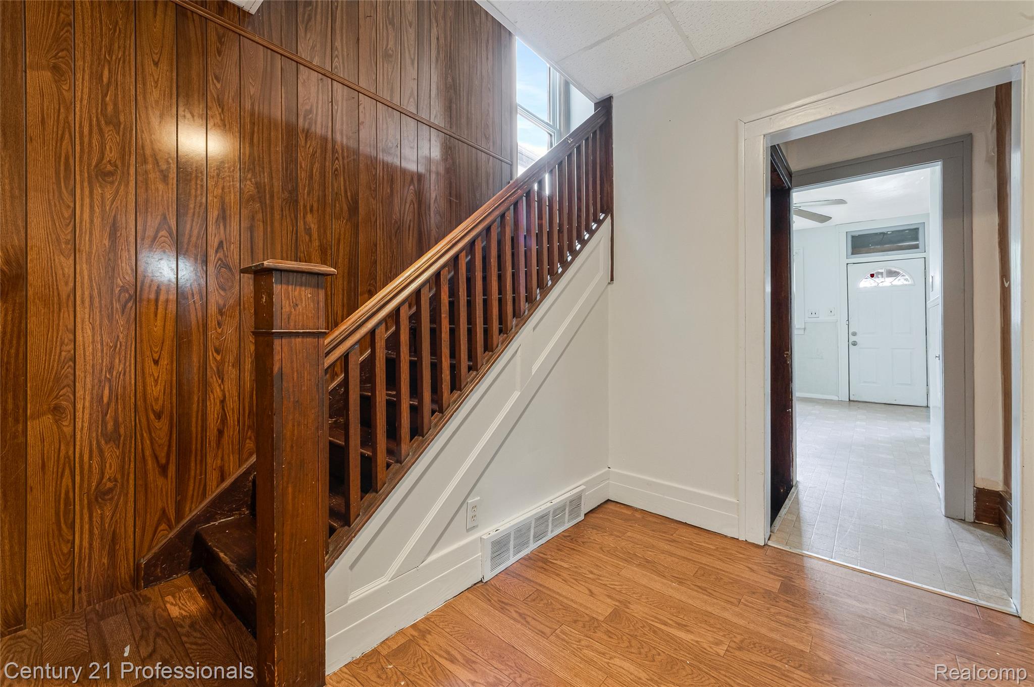 238 Richter Street River Rouge, MI 48218 - Photo 9 of 33 Staircase featuring wood-finish paneling, wood-finish flooring, and white painted risers with a matching banister